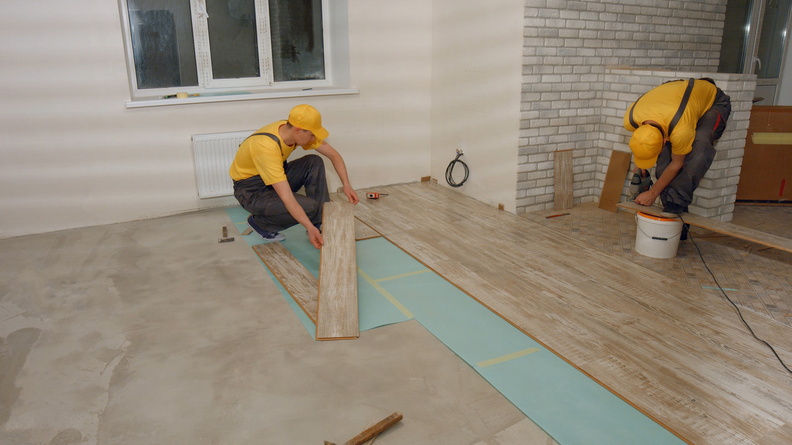 builders-laying-wooden-laminate-boards-on-floor-2021-09-23-02-55-43-utc.jpg