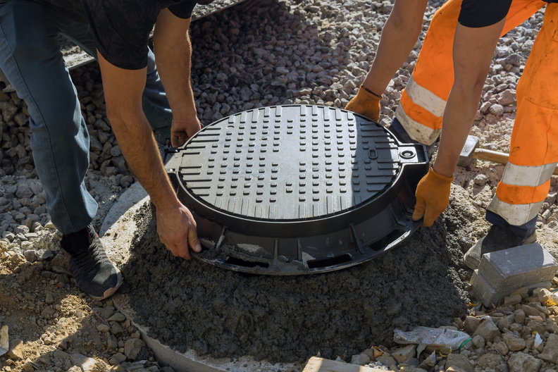 a-worker-installs-a-sewer-manhole-on-a-septic-tank-2022-02-13-17-50-27-utc.jpg
